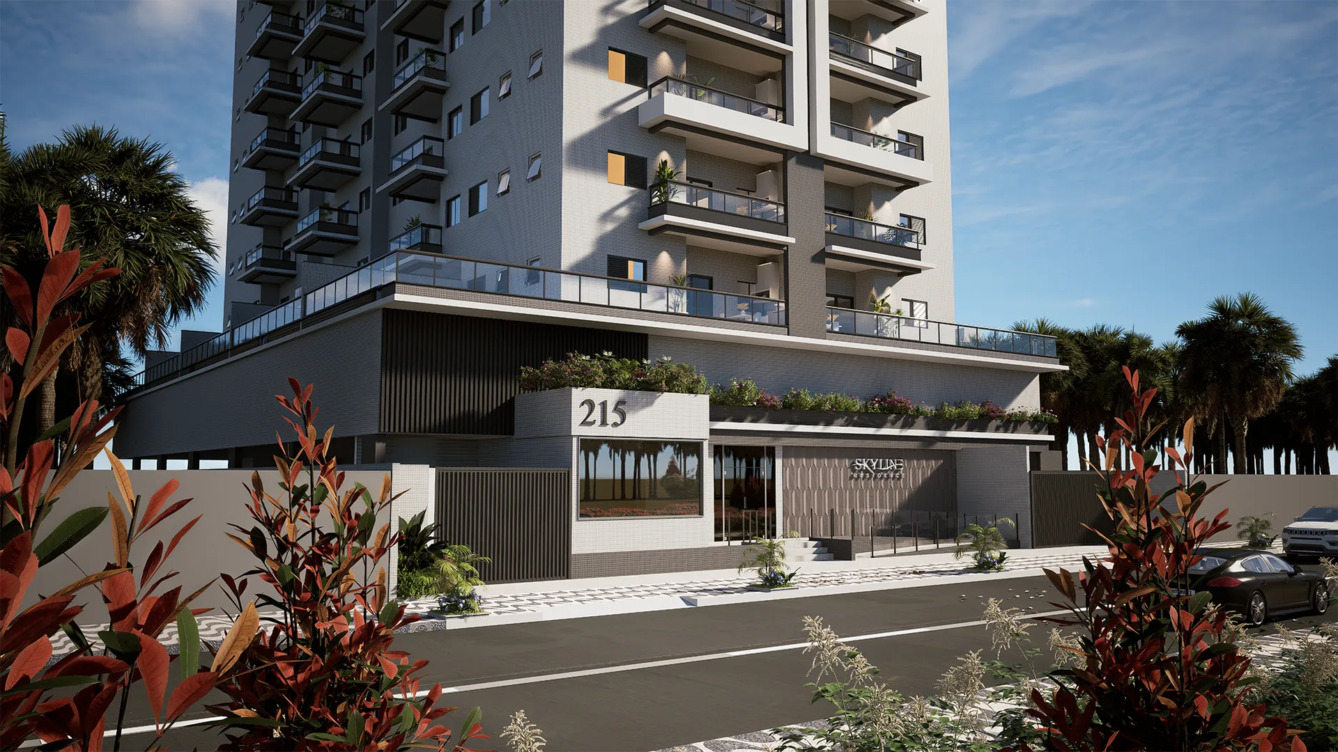 Portaria do Skyline Residence ao entardecer, com o número 215 e jardins floridos na entrada